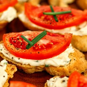 gluten free tomato crostini with chive cross on top.