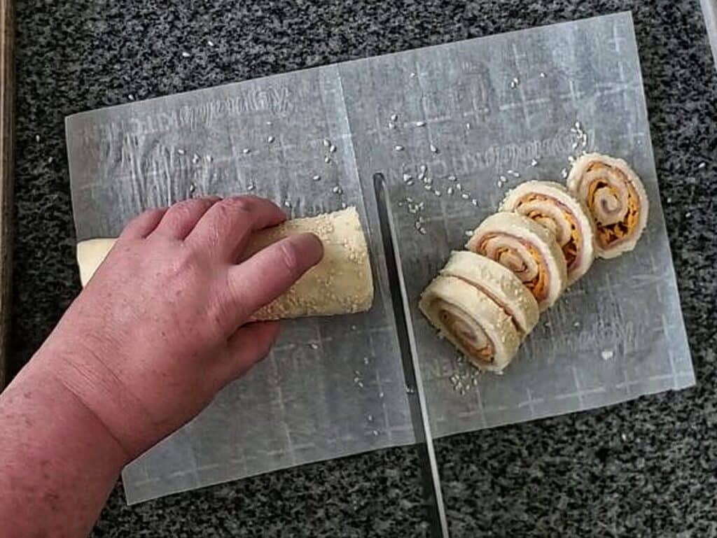cutting chilled dough into slices that look like spirals.