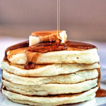 stack of gf fluffy pancakes drizzled with syrup.