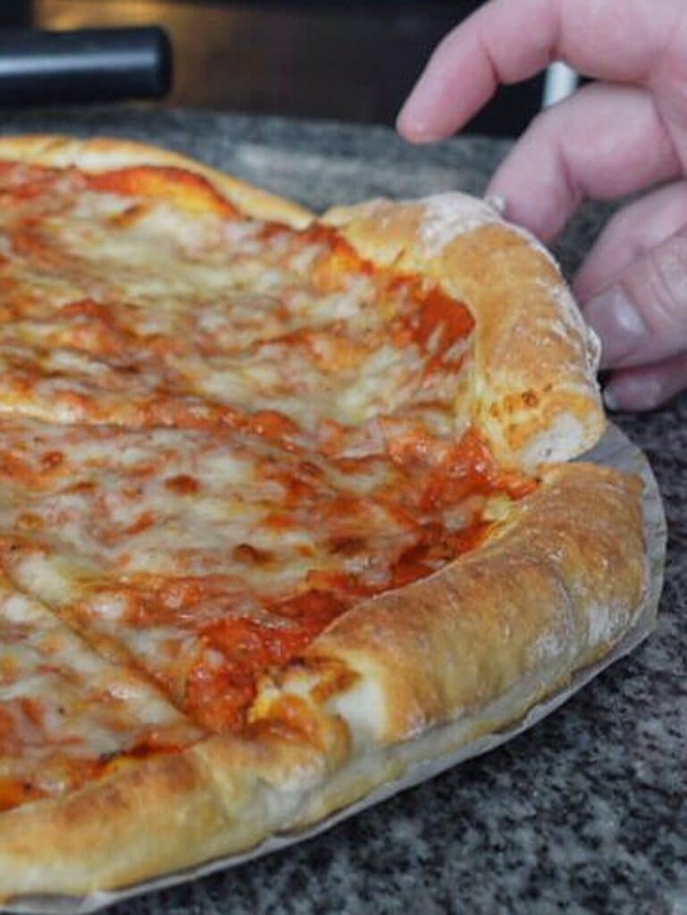 pulling a slice of pizza from the whole pie.