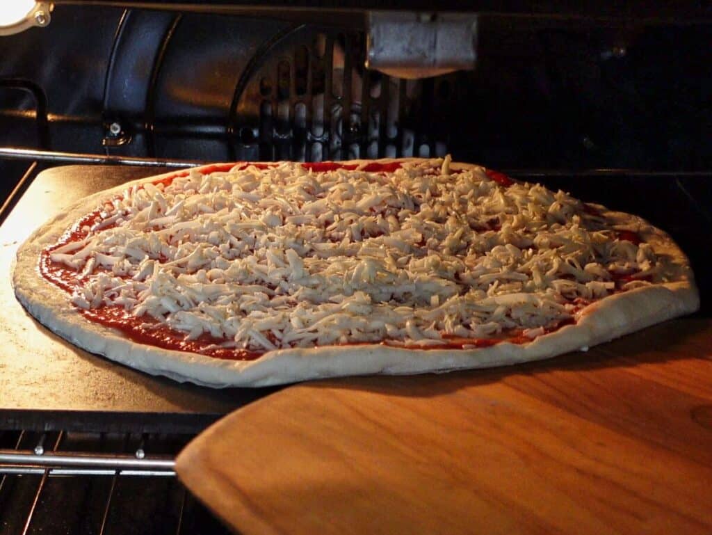 launching gf pizza into oven on pizza steel, using a wooden pizza peel.