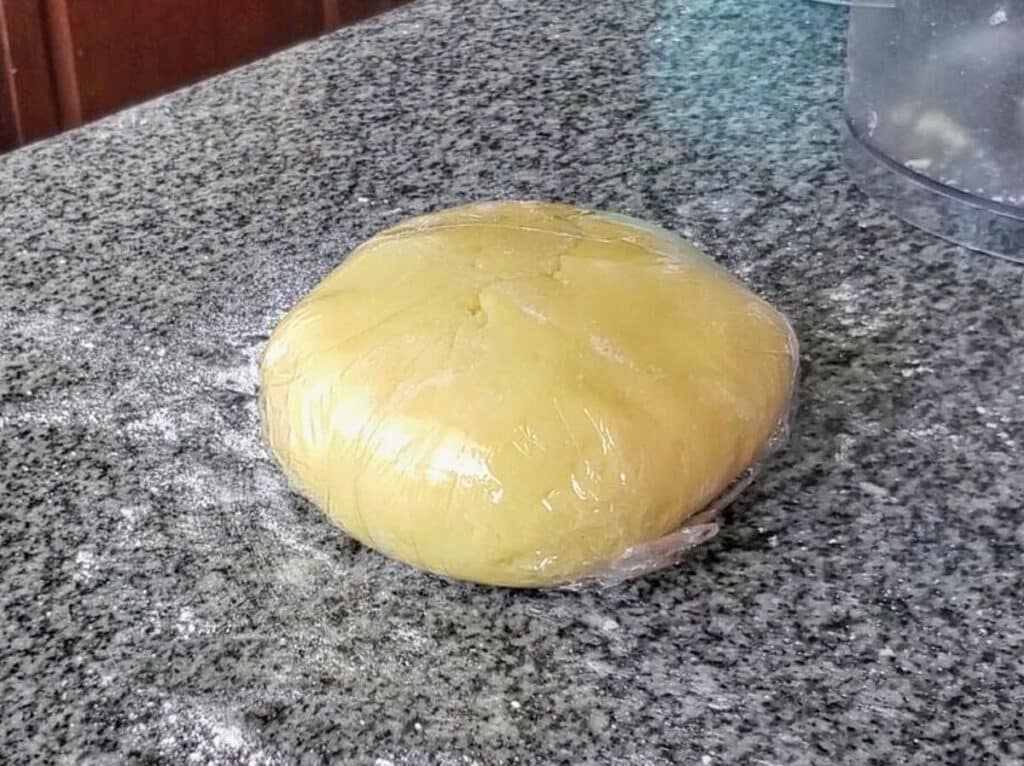 wrapping pasta dough in plastic wrap.