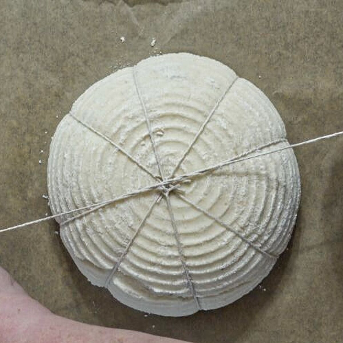 tying strings on top of dough to form pumpkin shape.