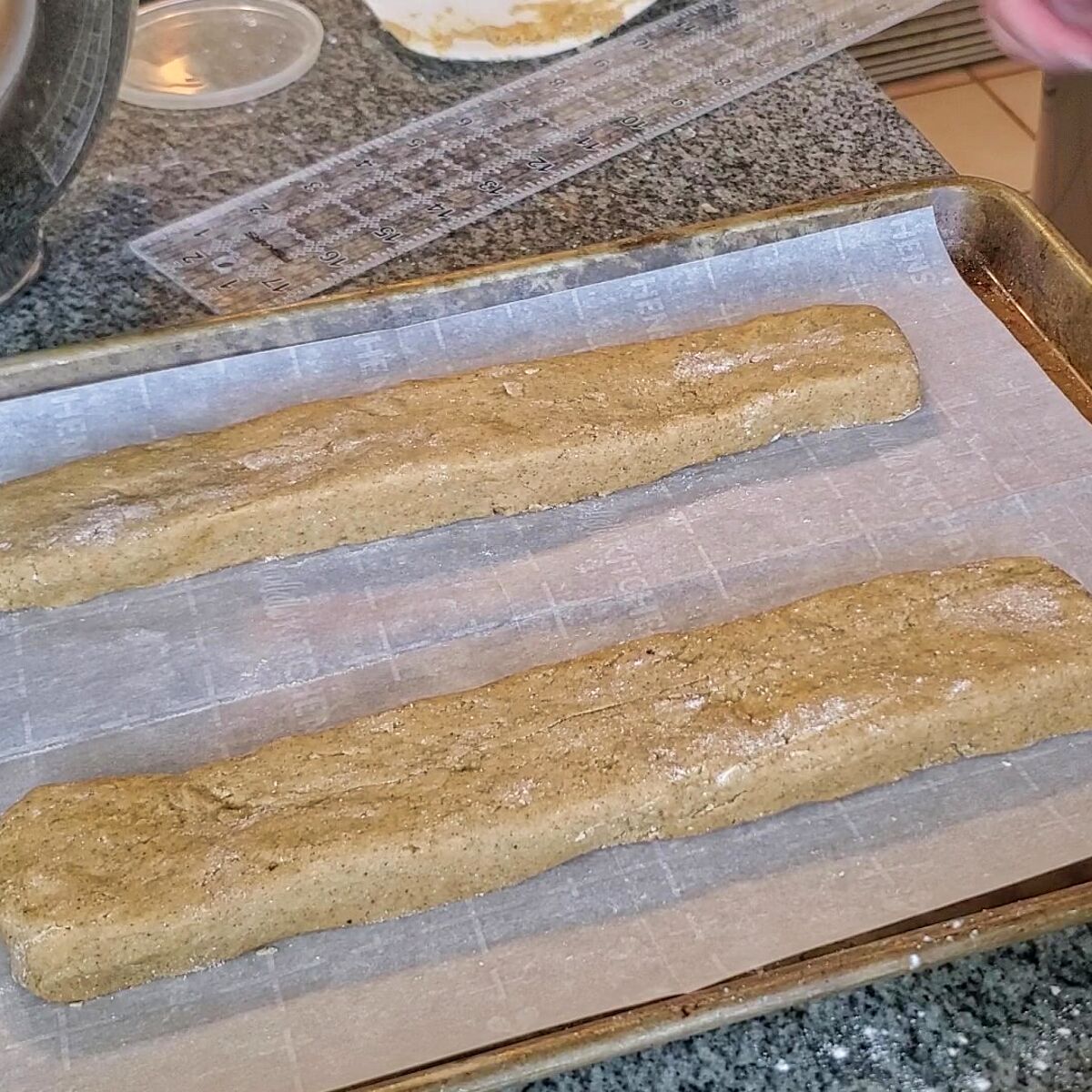two 2 by 12 inch loaves of gingerbread dough on parchment.