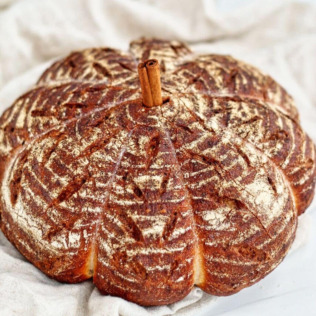 pumpkin shaped sourdough on a light beige linen.