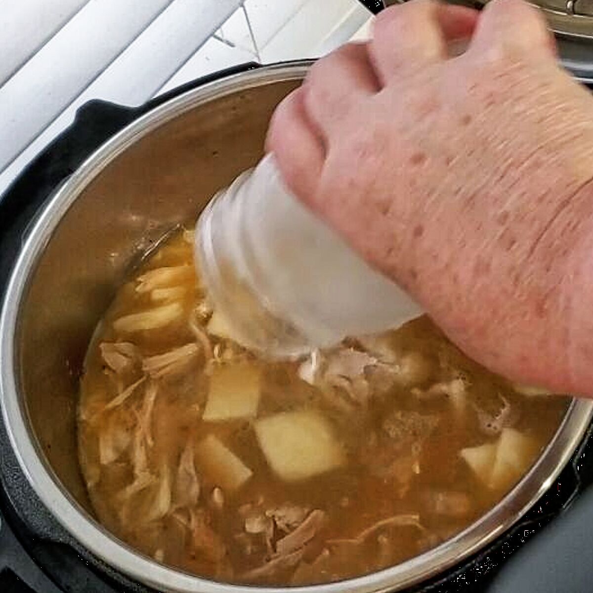 adding cornstarch slurry to chicken and dumplings to thicken.