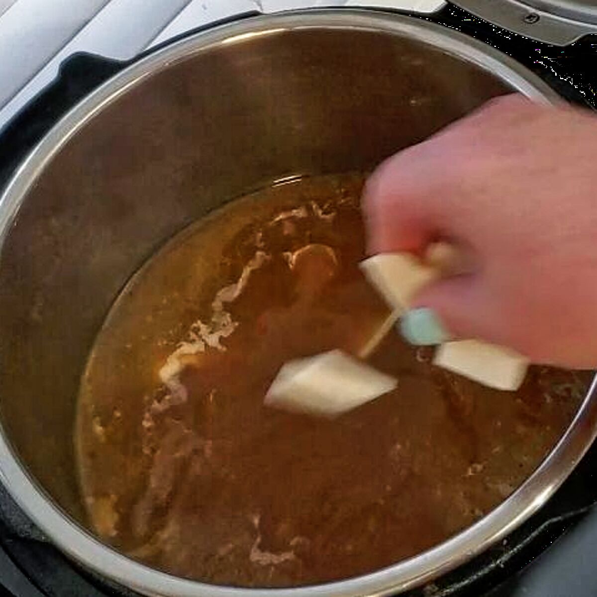 adding dumplings to boiling chicken stock in instant pot.