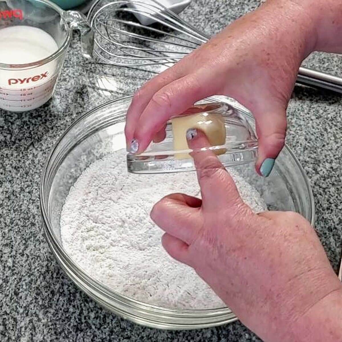 Adding softened butter to flour mixture in bowl.