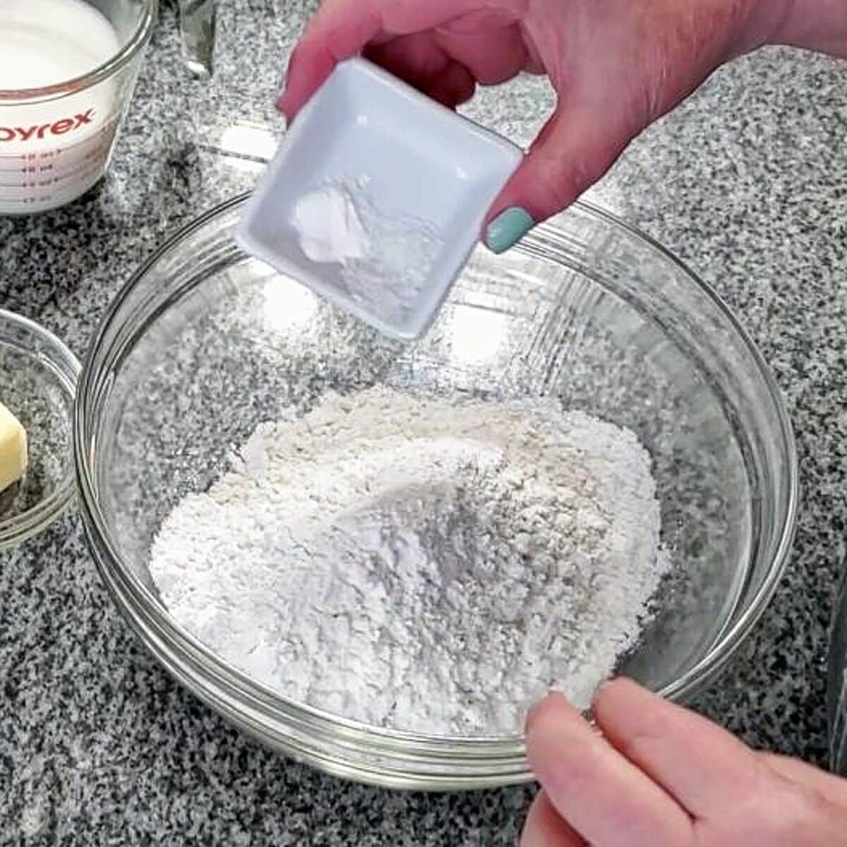 adding baking powder and salt to gf ap flour in glass bowl.