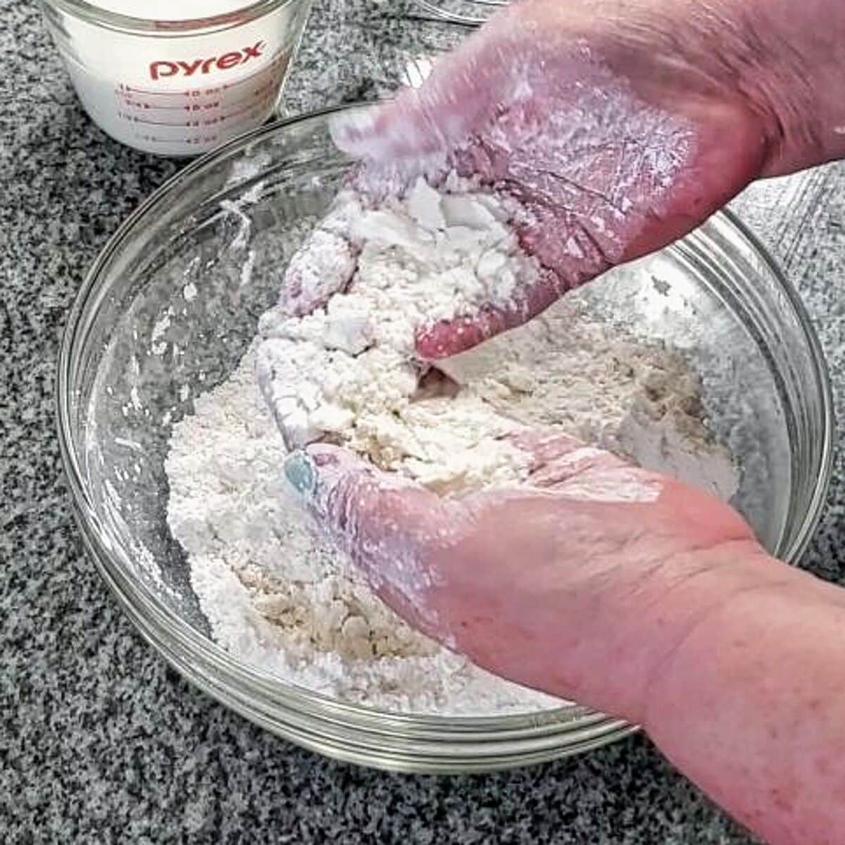 butter mixed into flour mixture with hands.