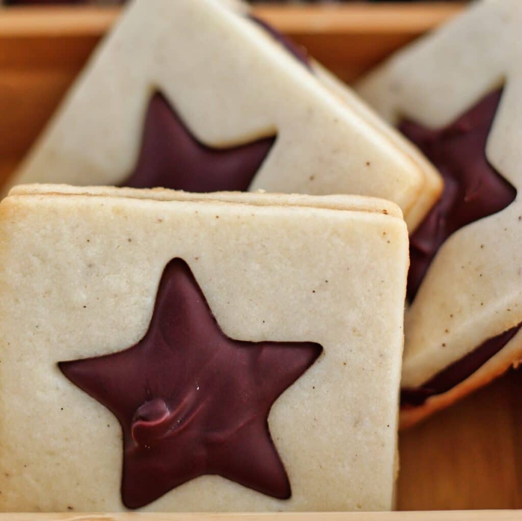 chocolate sandwich cookies with star cutout in wooden box.