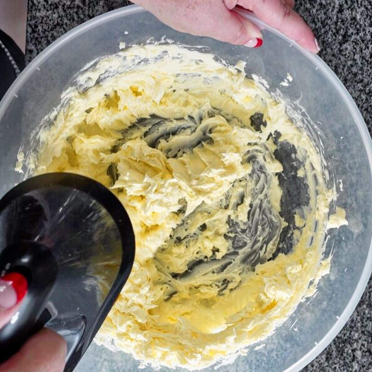 beating butter in a large plastic bowl with handheld mixer.