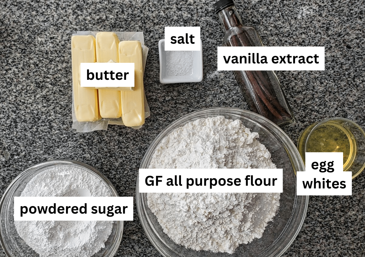 ingredients for butter cookies measured out and labeled on granite countertop.