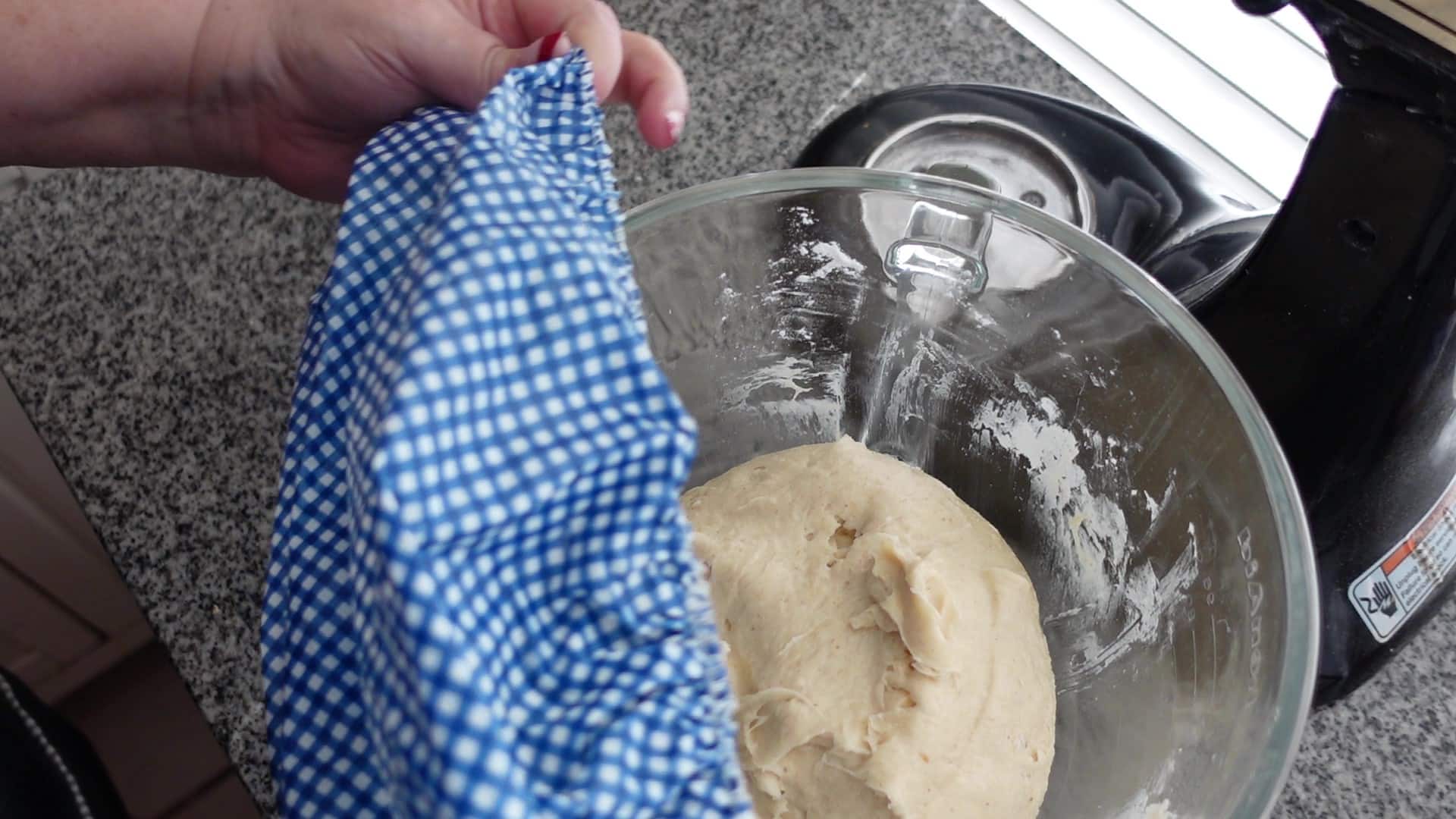 covering dough with blue showercap.