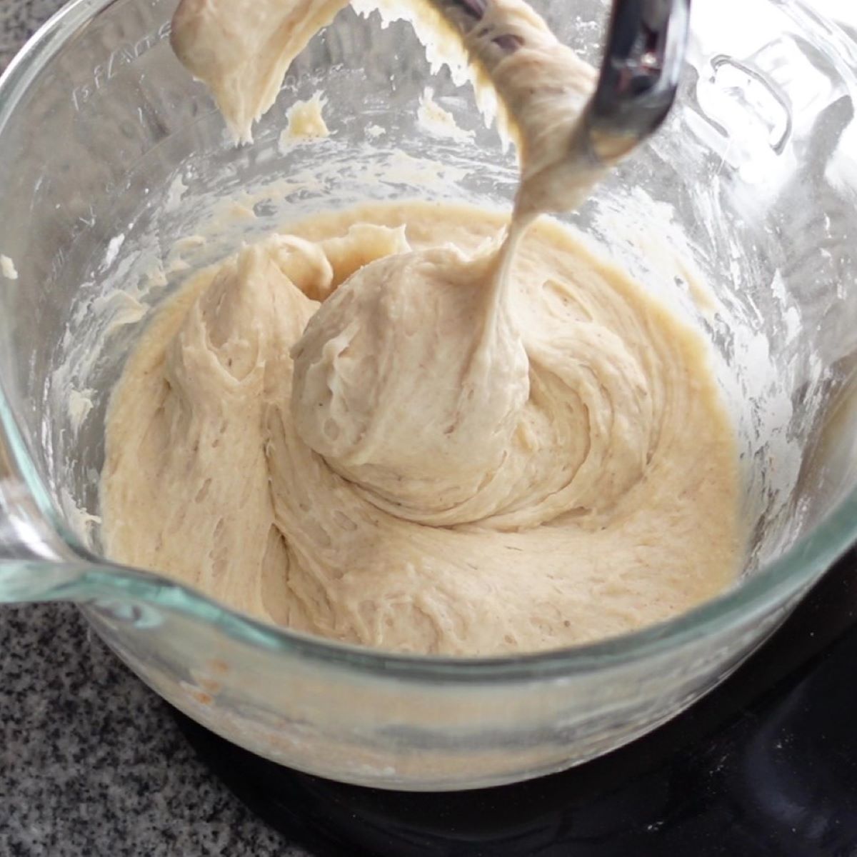 mixing dough in glass bowl of stand mixer with dough hook.