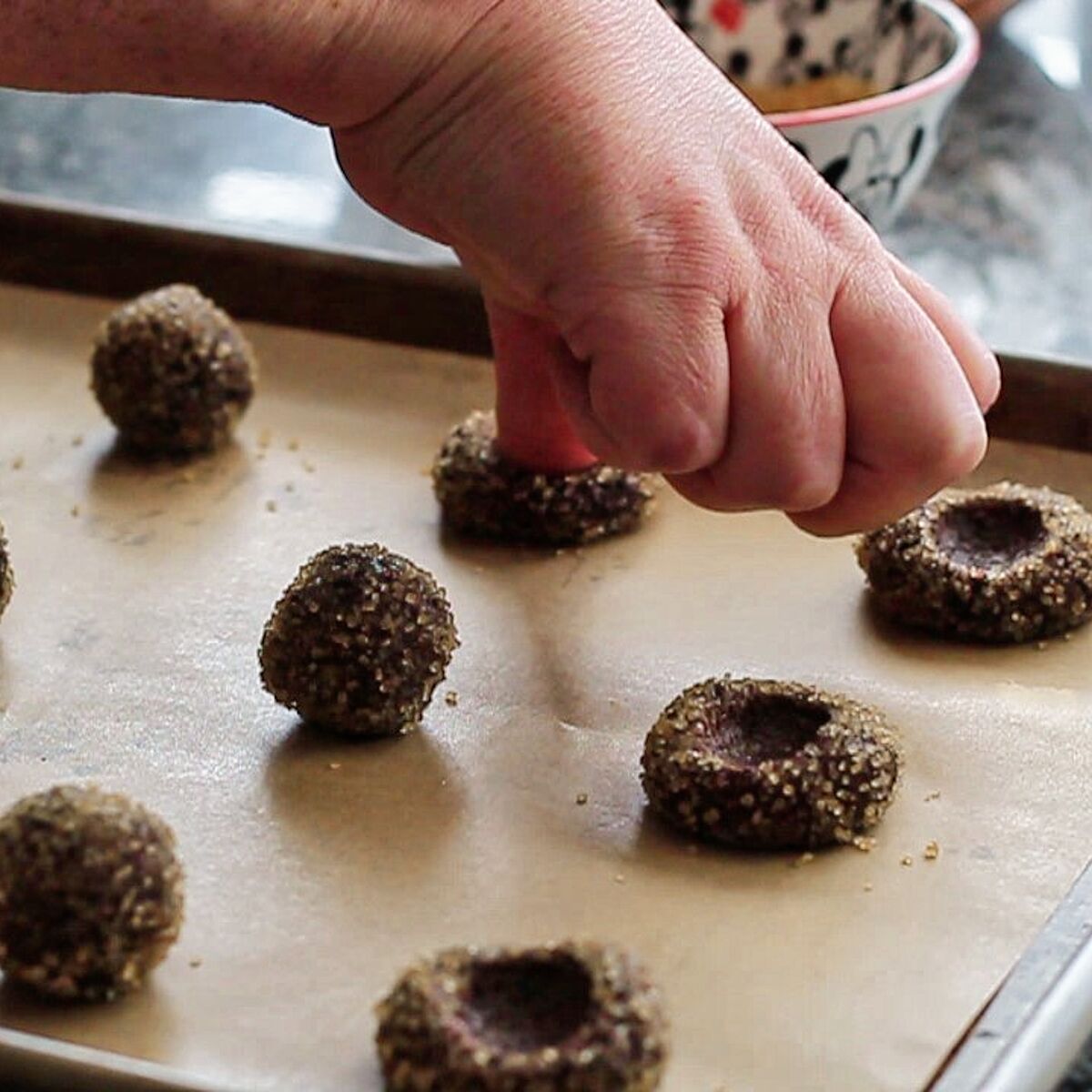pressing thumb into each ball of chocolate dough.