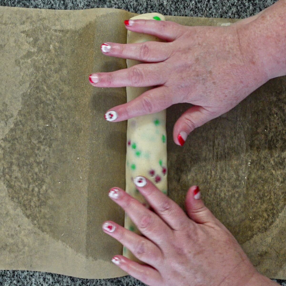 rolling m&m dough into a log on parchment.