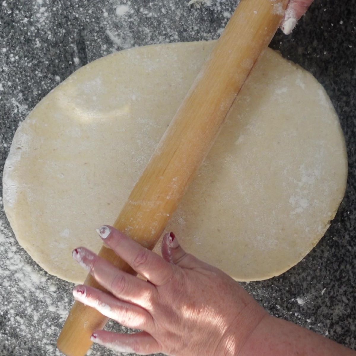 rolling out dough on granite countertop.