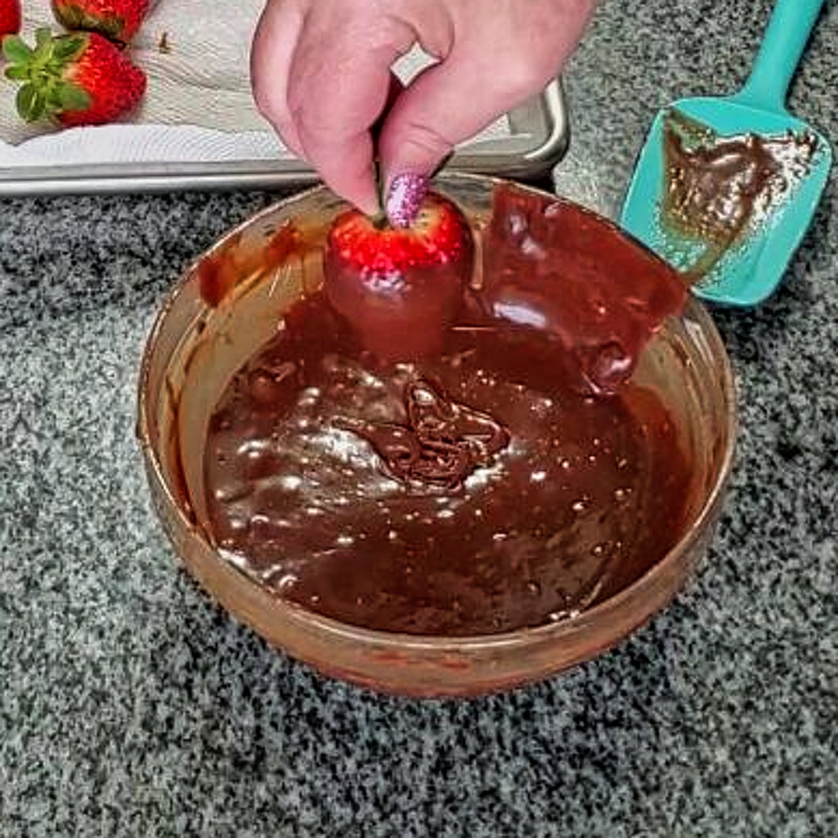 dipping strawberry in chocolate ganache.