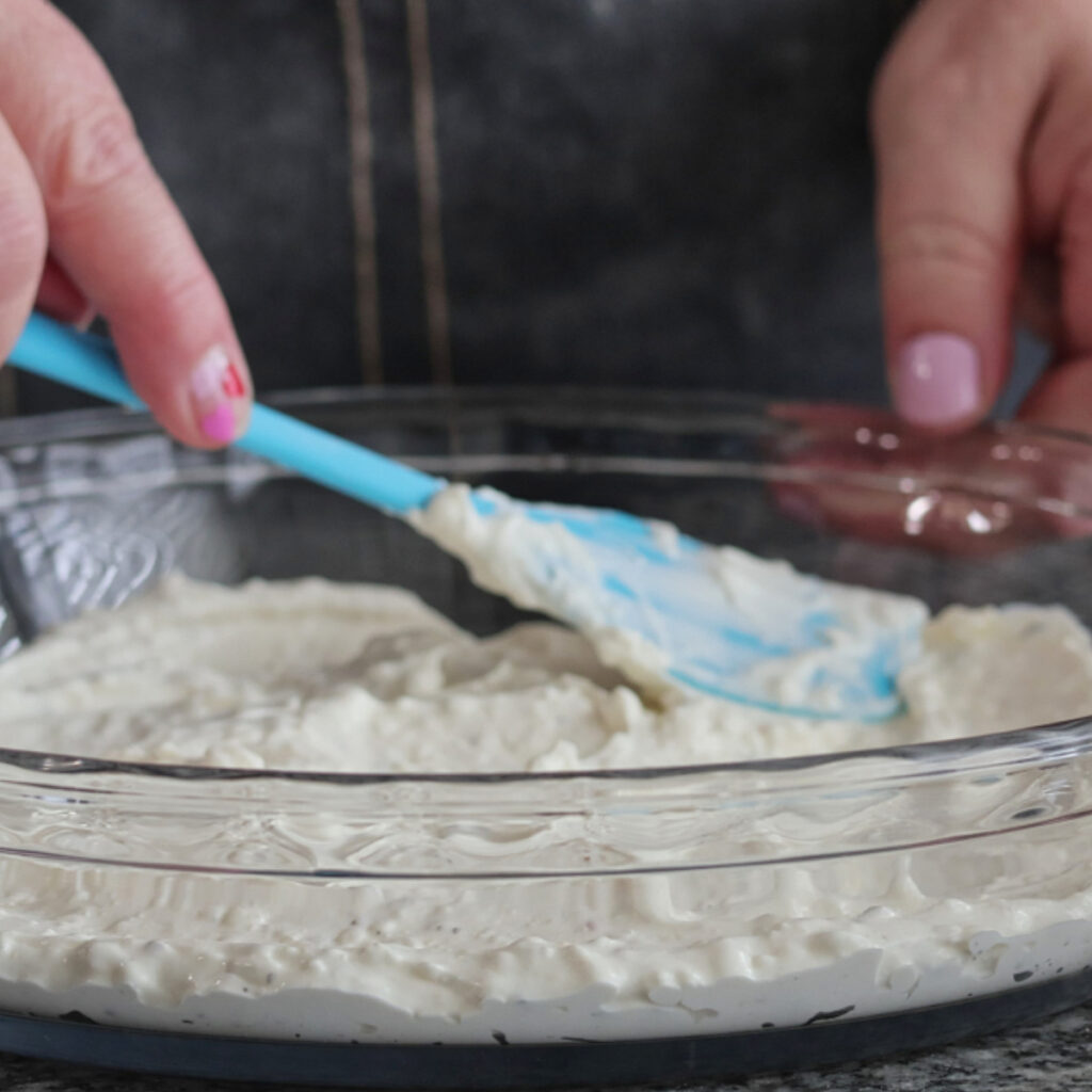 pouring pizza sauce on cream cheese layer