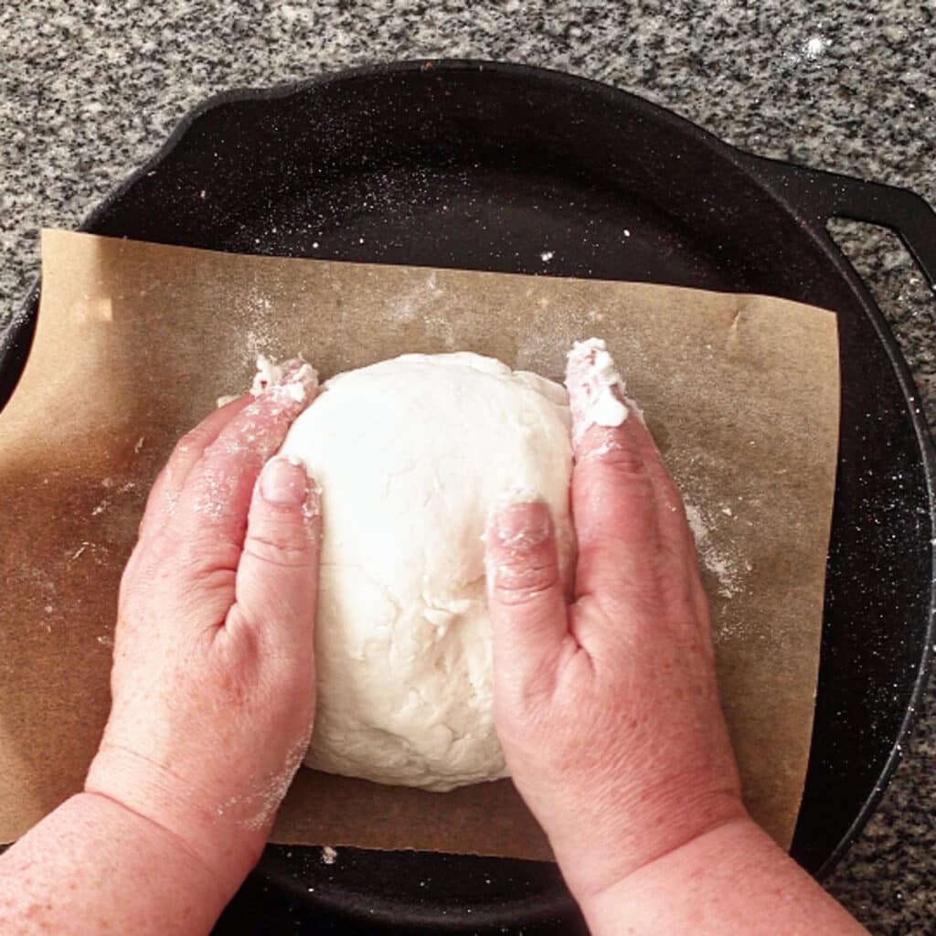 dumping dough onto parchment-lined baking sheet