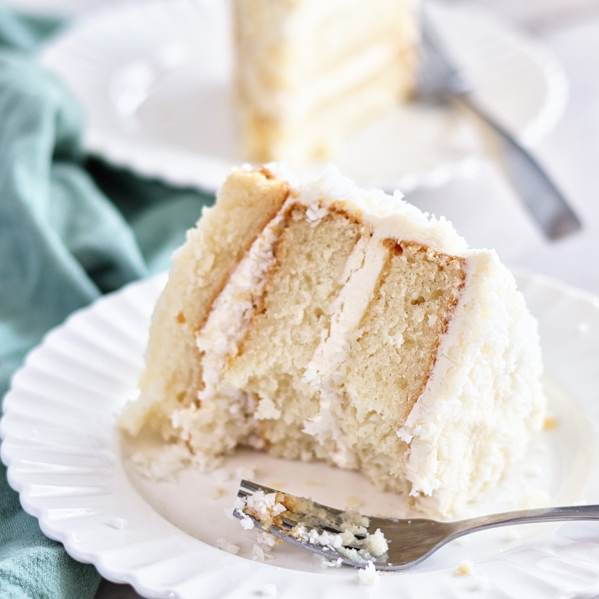 half eaten slice of gluten free coconut cake on white plate.