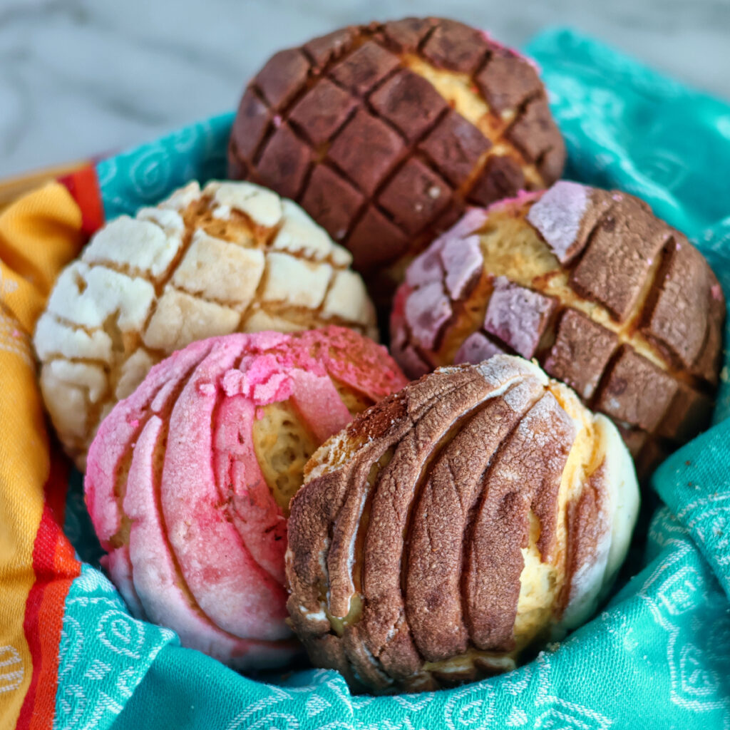 white bowl with gluten free mexican conchas in pink and orange colors