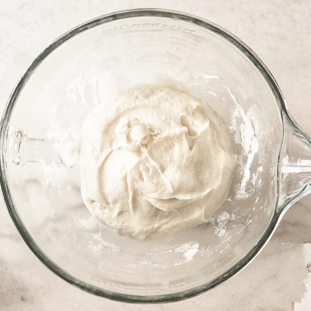 scraping dough together into center of glass bowl.