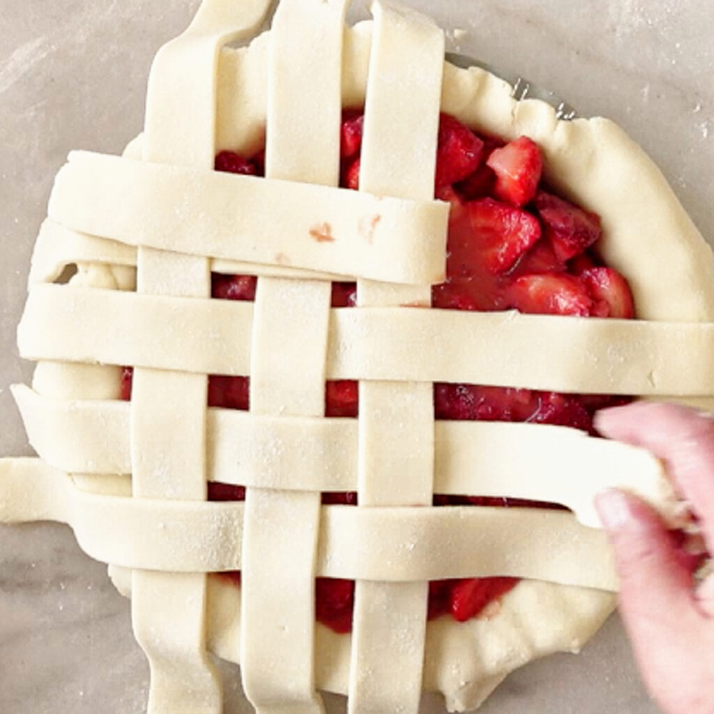 forming strips of pie dough into a lattice pattern on top of filling.