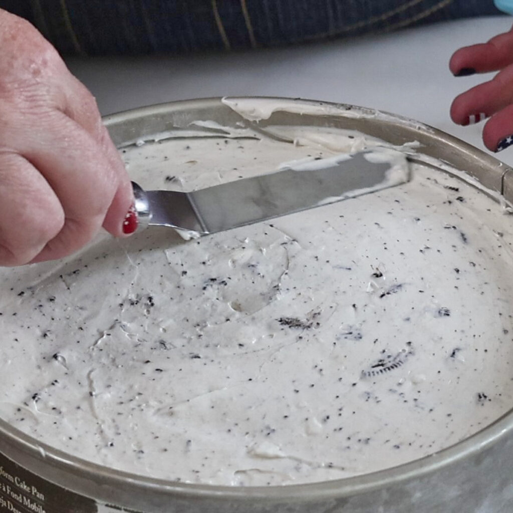 smoothing top of cheesecake in springform pan.