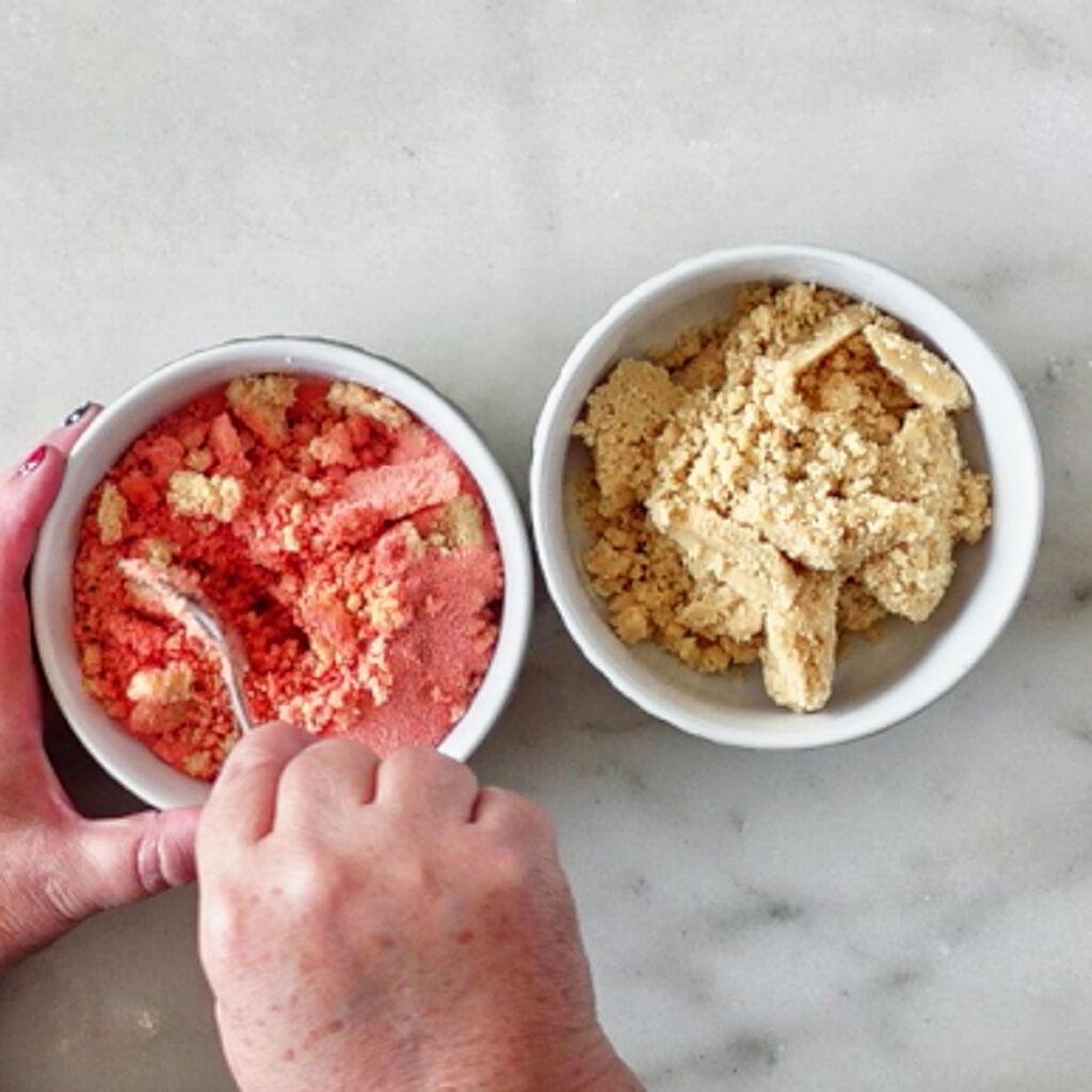 stirring strawberry jello powder into one bowl of cookie crumbs.