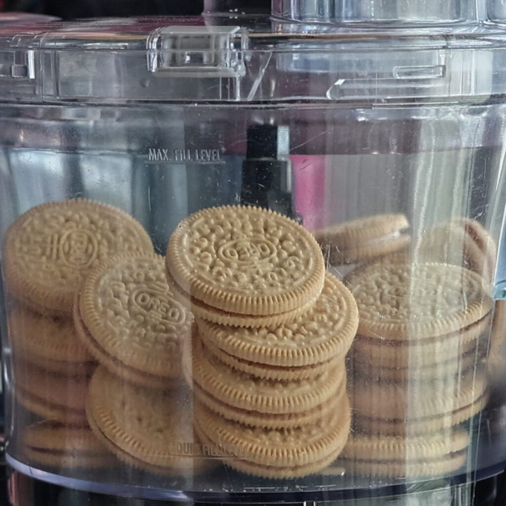 whole vanilla sandwich cookies in food processor bowl.