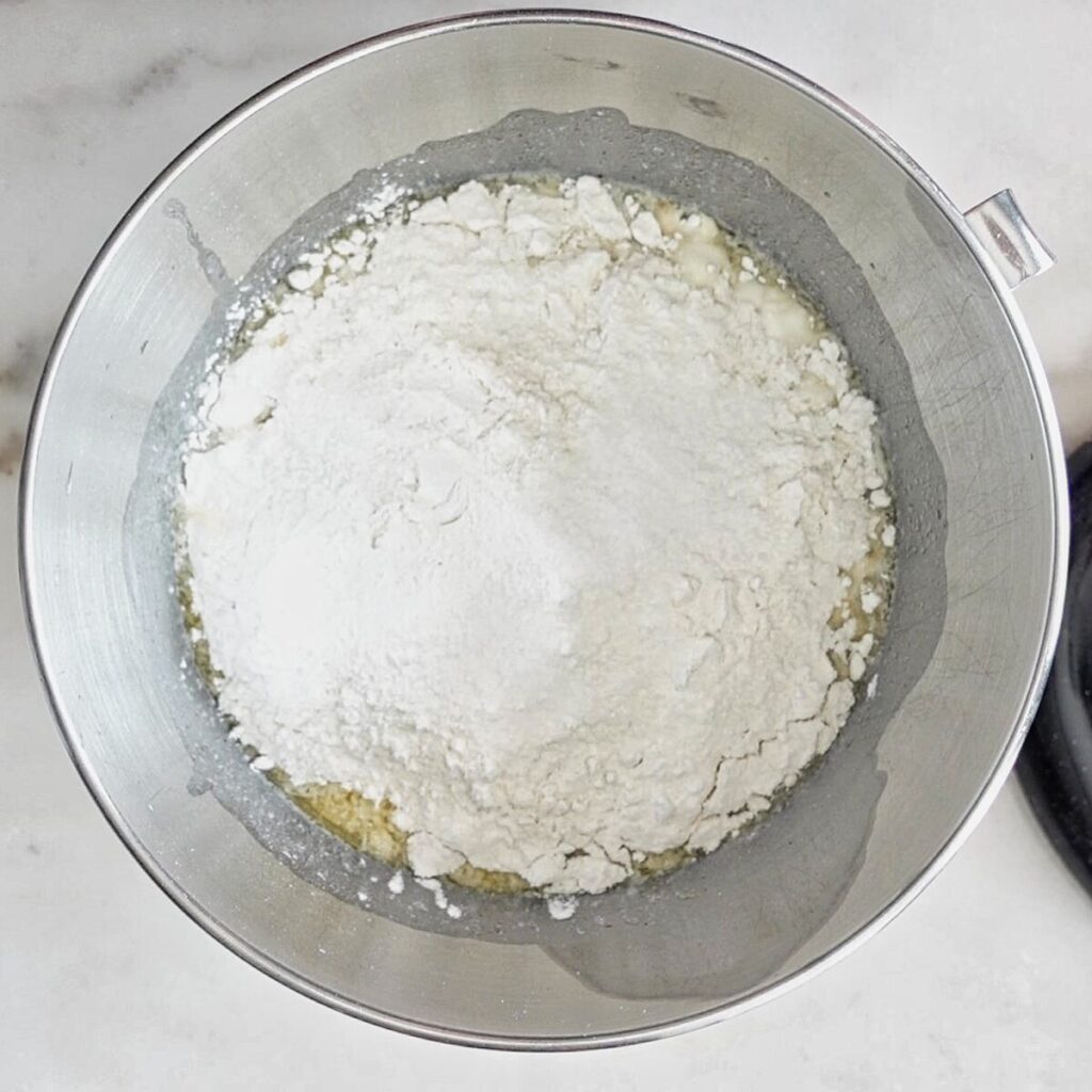 all ingredients for bread dough in stainless steel mixing bowl.