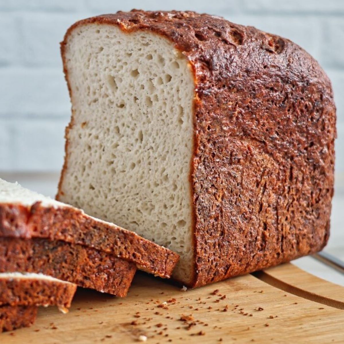 half cut loaf of bread on cutting board.