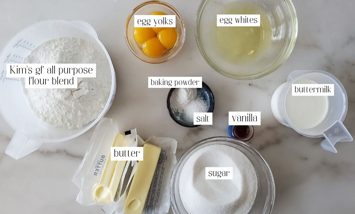 cake ingredients measured out and labeled on white marble countertop.
