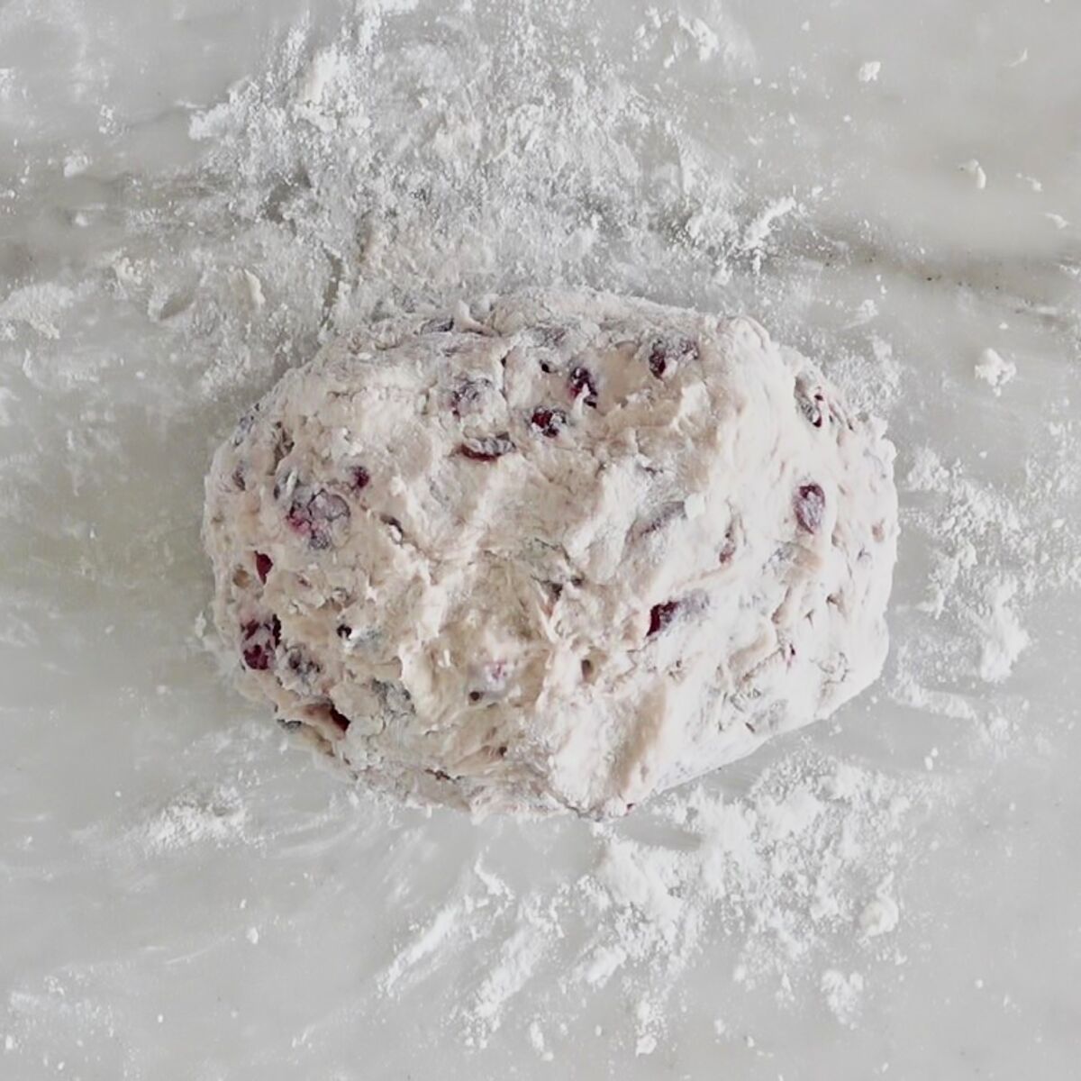 kneaded dough on white marble surface.