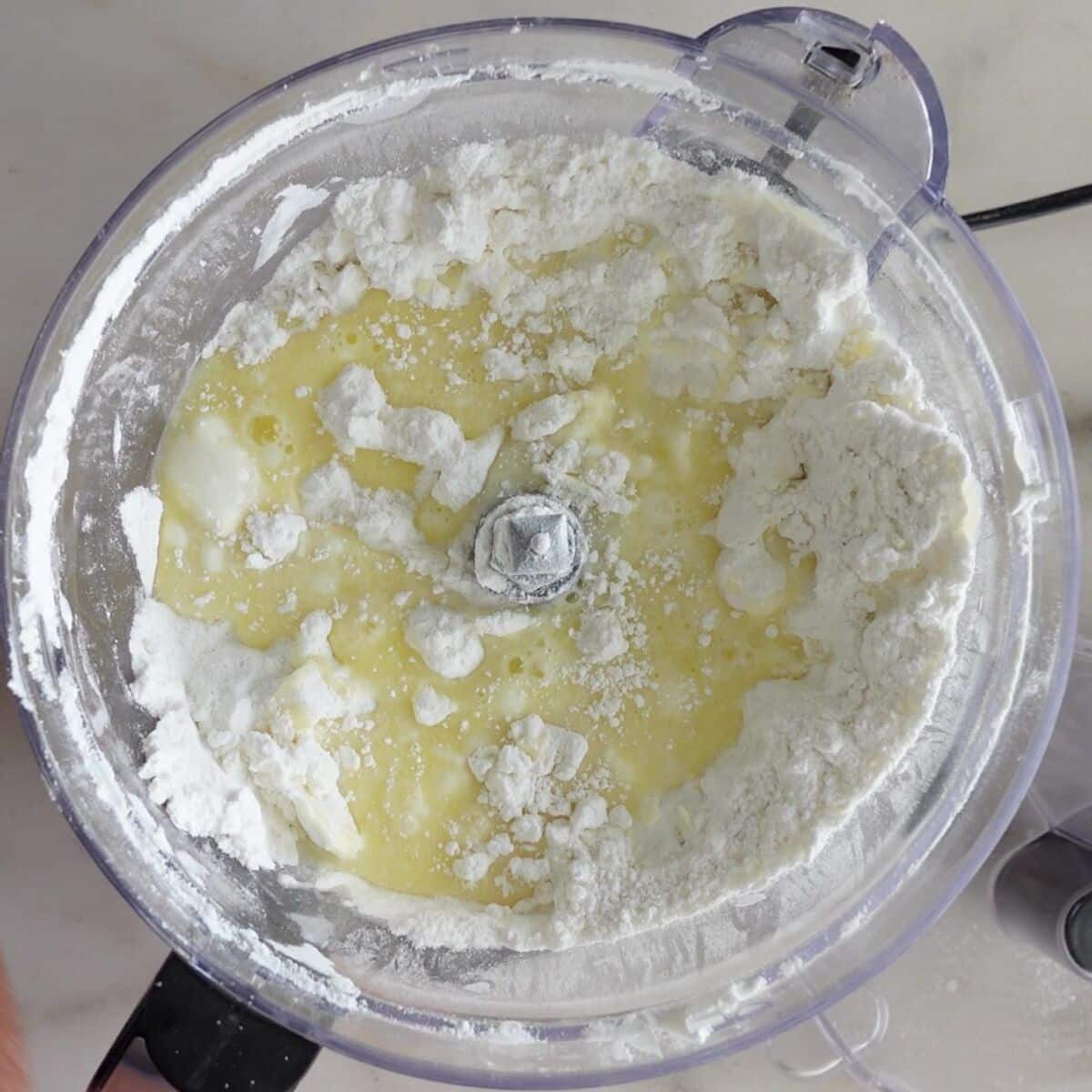 egg and water mixture added into butter and flour mixture in food processor.