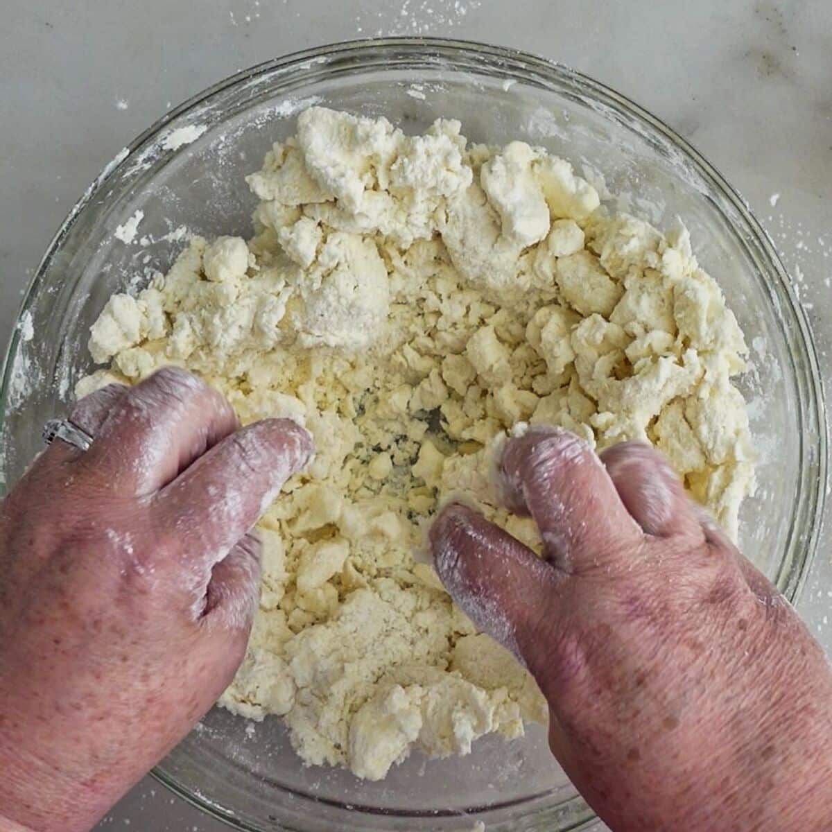 tossing butter and flour mixture with wet ingredients until small chunks of dough start coming together.