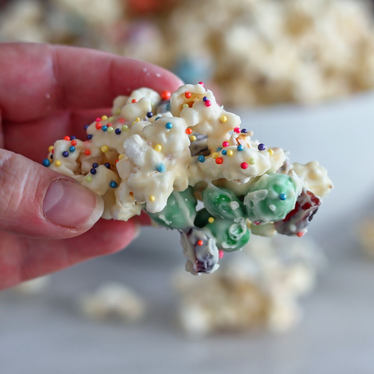 cluster of white chocolate popcorn with candies attached.