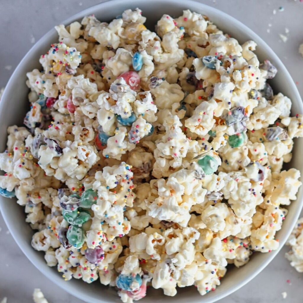 overhead shot of white chocolate popcorn in small pails with popcorn scattered about