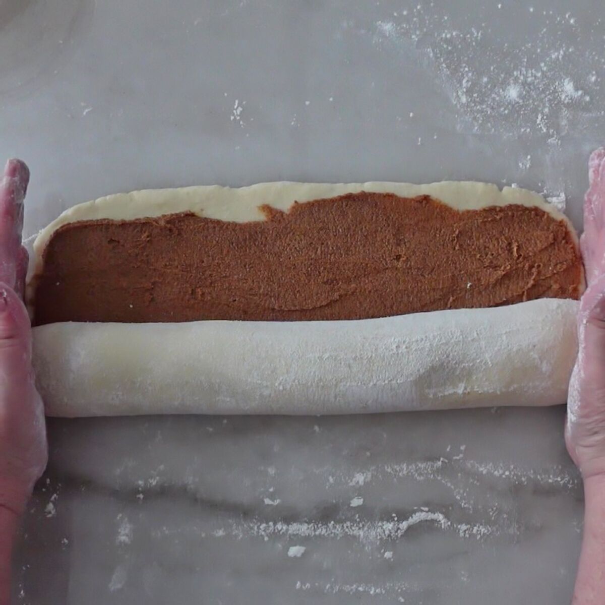 rolling up dough into a log.