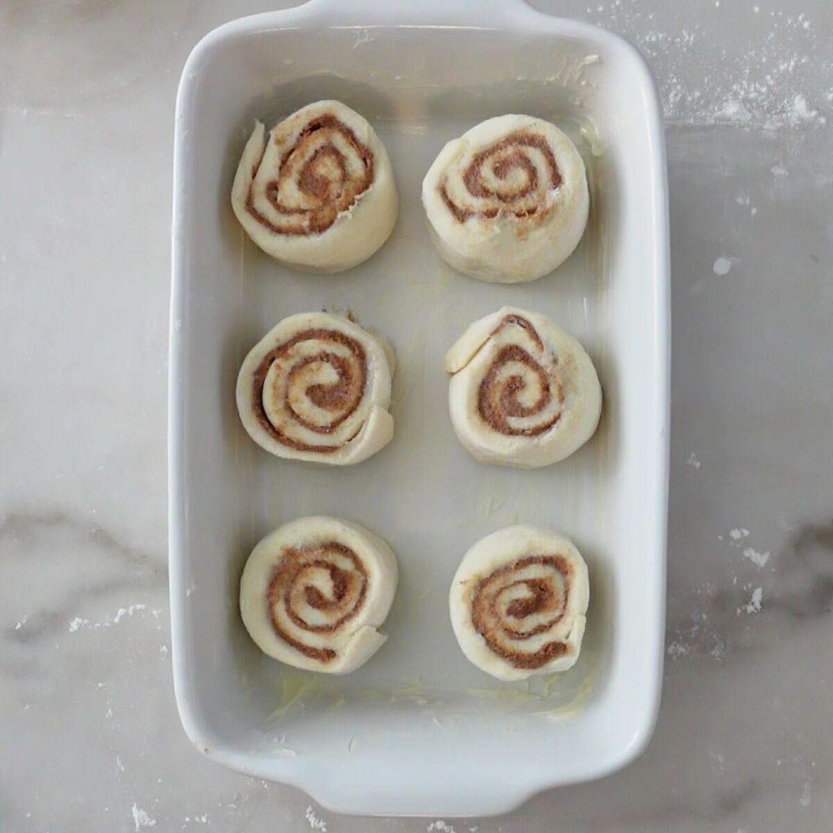 six rolls in white rectangular baking dish.