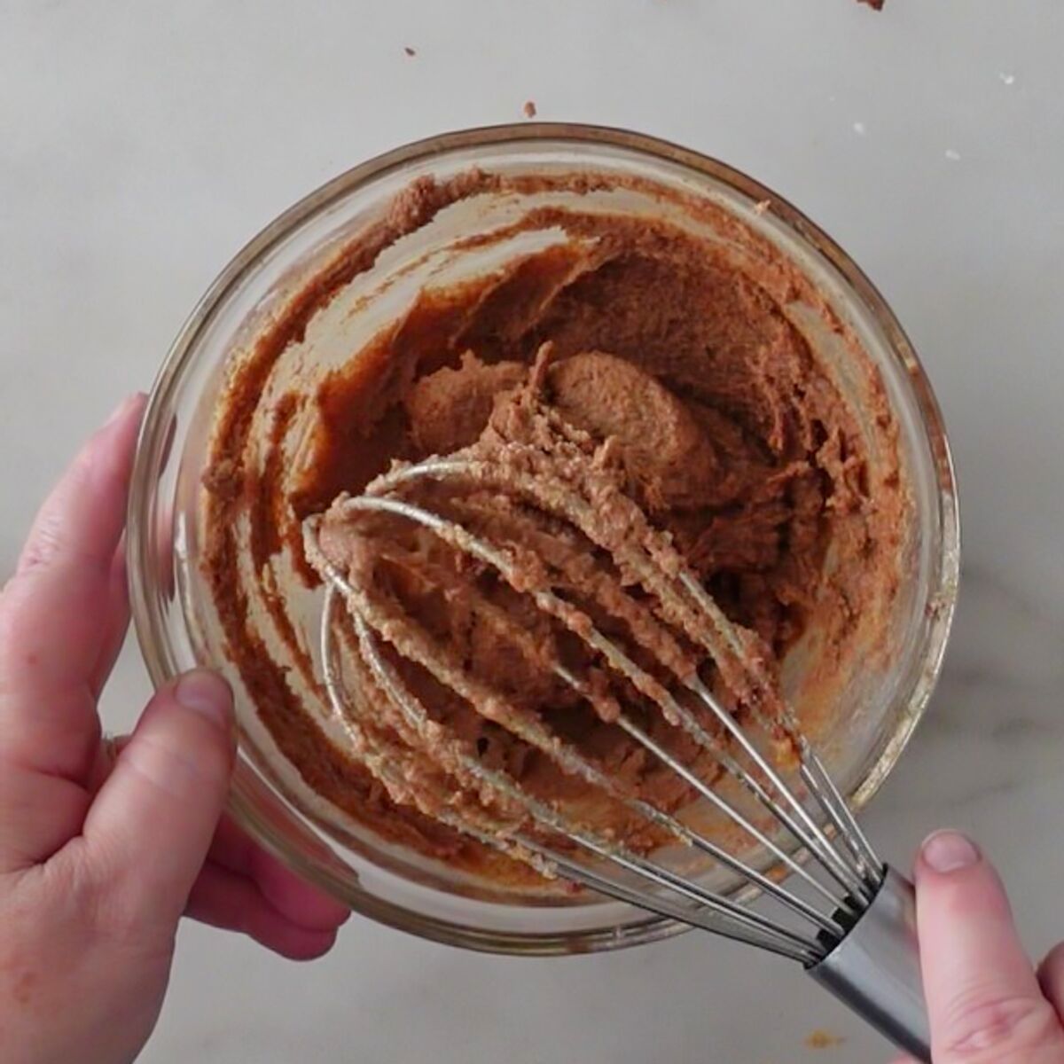 whisking brown sugar filling in small glass bowl.
