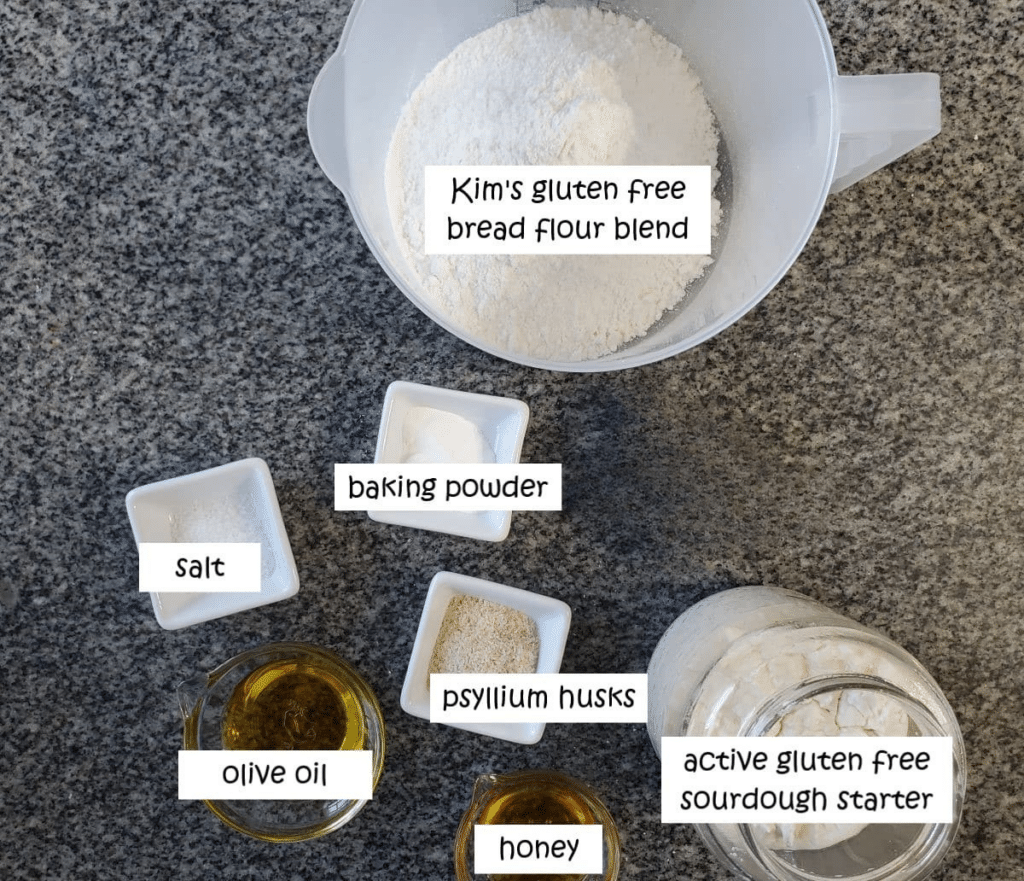 ingredients for gf sourdough measured out and labeled on granite countertop.