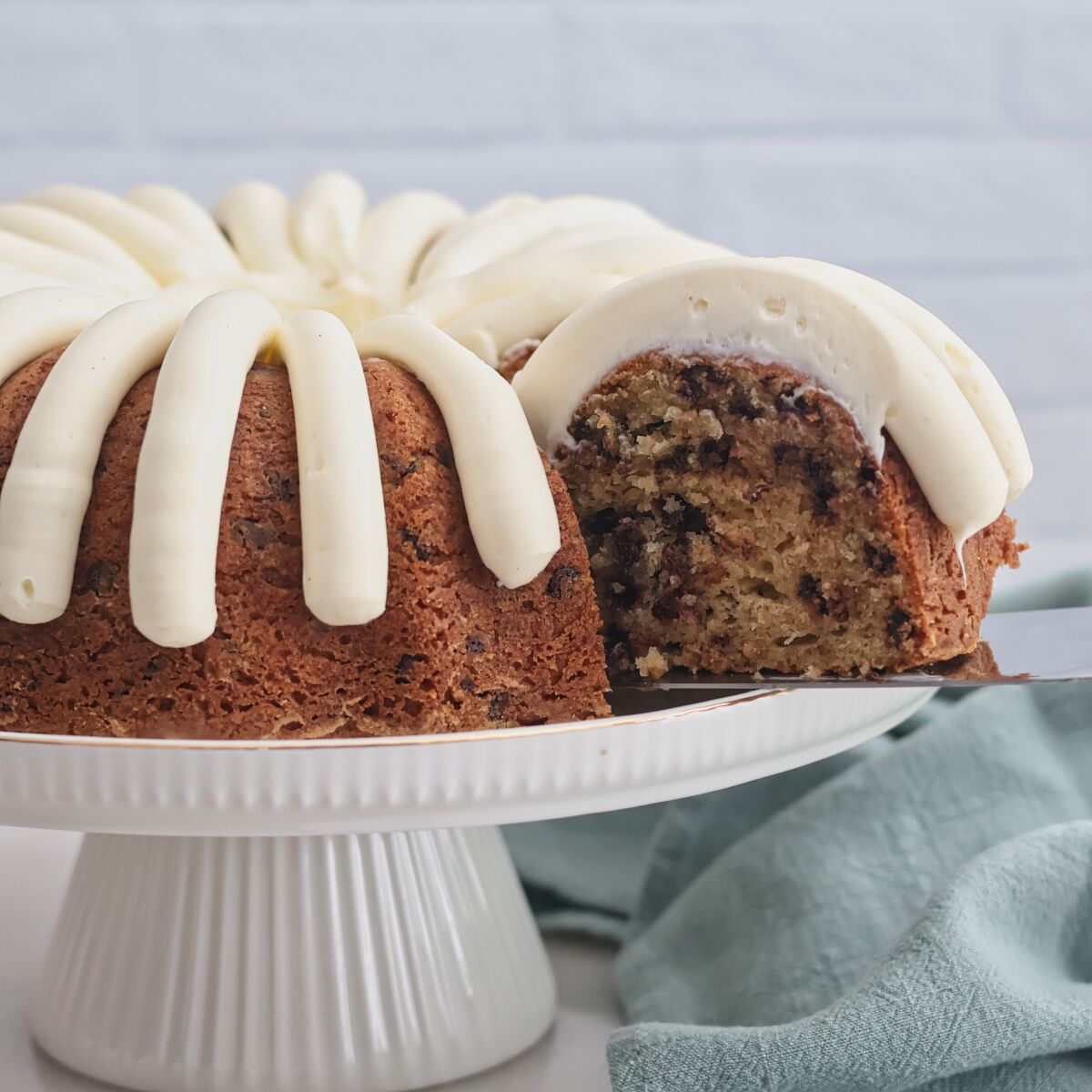 removing one slice of cake from white cake platter.
