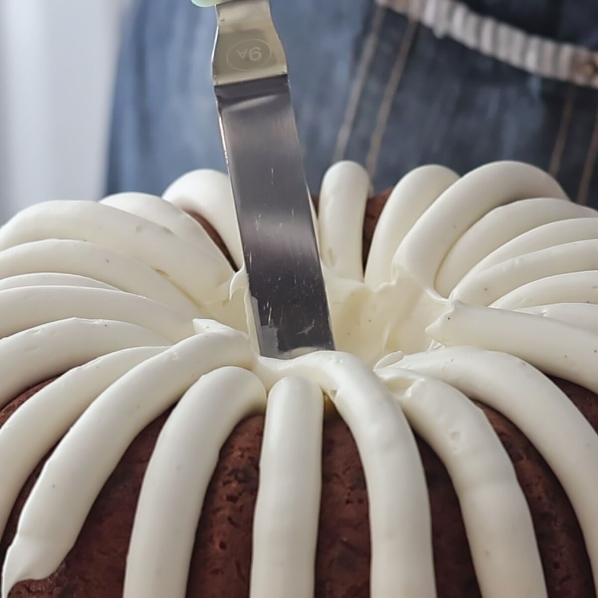 smoothing frosting inside middle hole of cake.