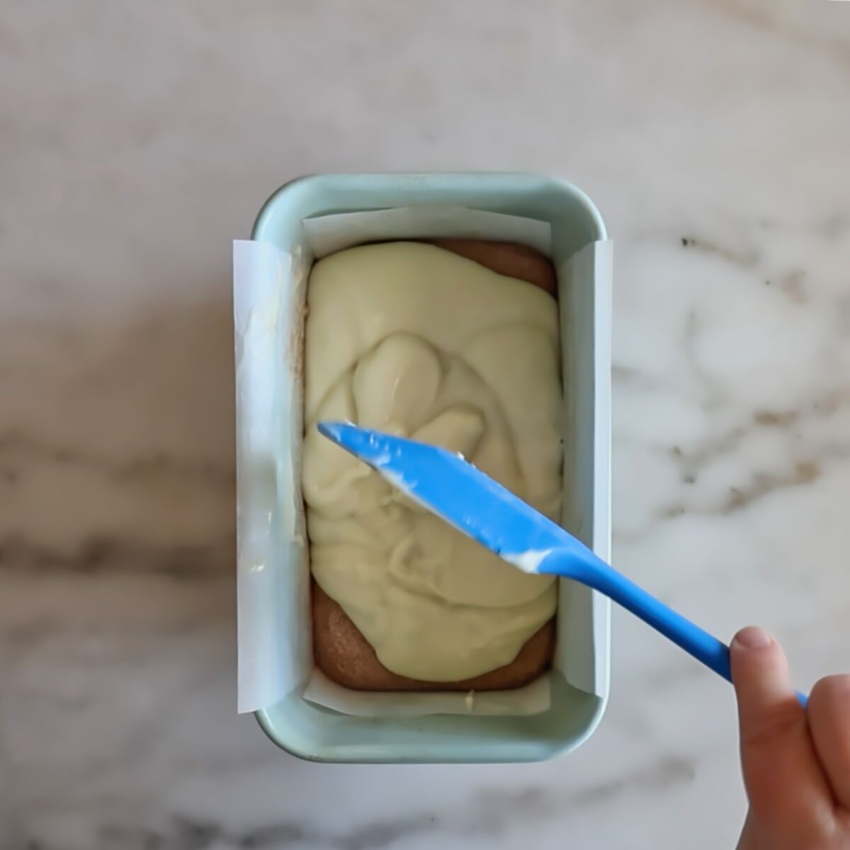 spreading the rest of the batter over cinnamon and sugar in light blue loaf pan.