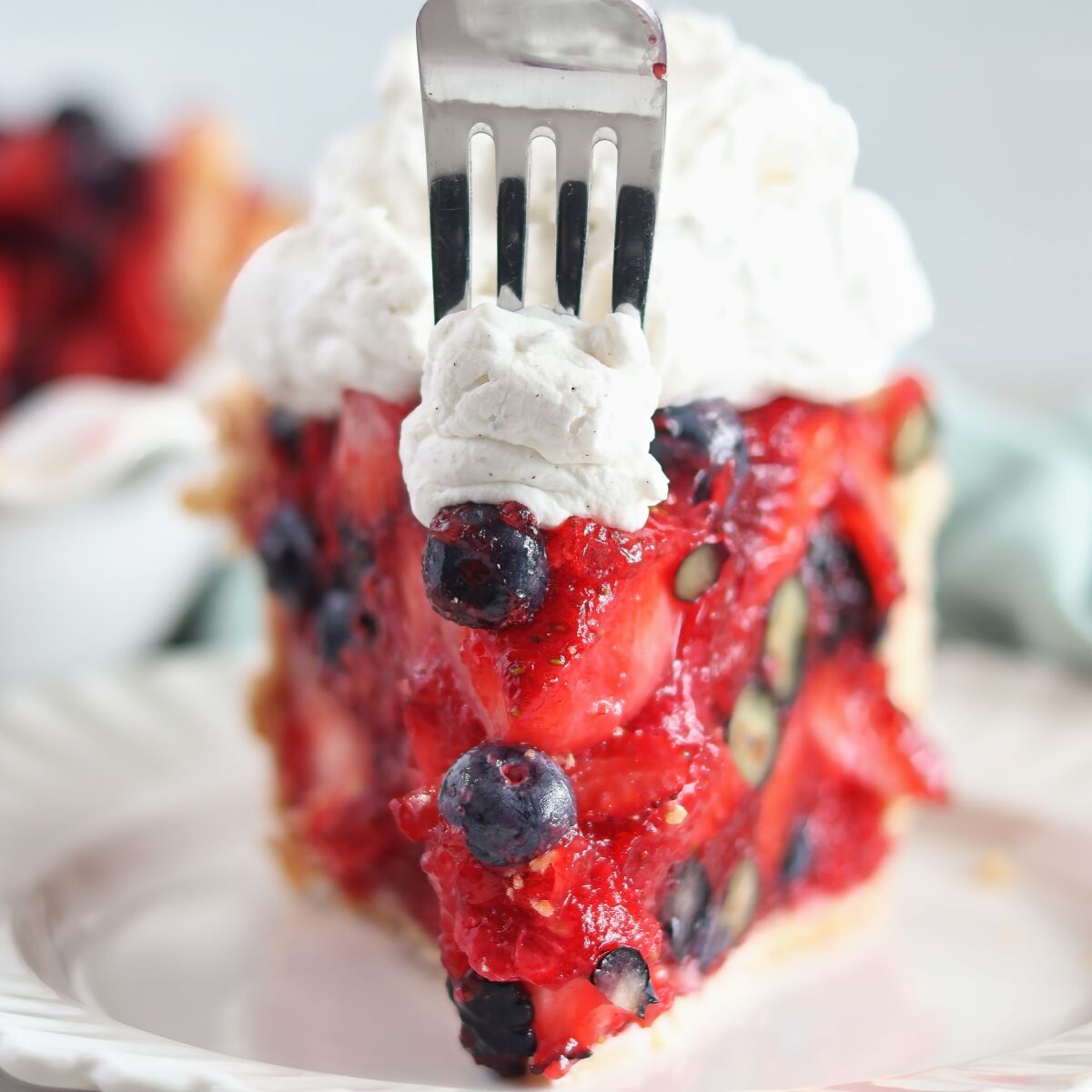 fork cutting into slice of pie and whipped cream at the point.