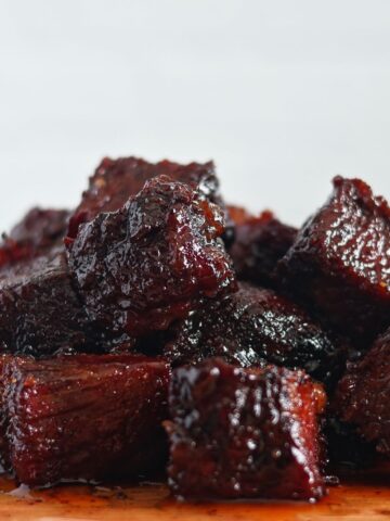 pile of burnt ends up close on wooden cutting board.
