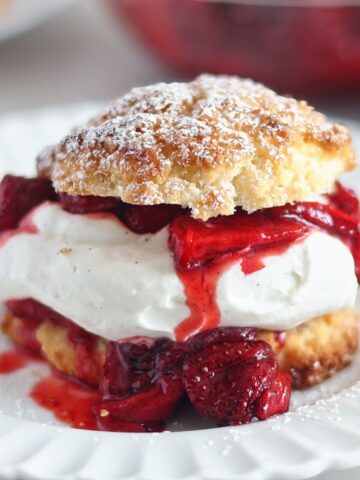 strawberry shortcake on white scalloped plate.